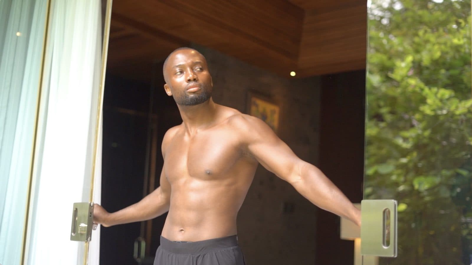 Grey Jabesi standing in an open doorway after training, used as the thumbnail for his via negativa fitness article.